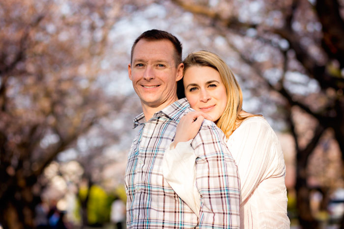 couple hugging in park during sakura season