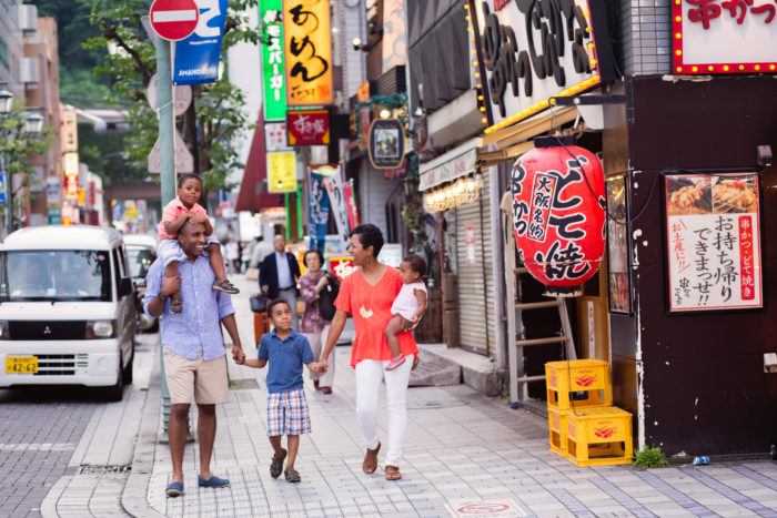 family of 5 walking in downtown Yokosuka Japan blue street